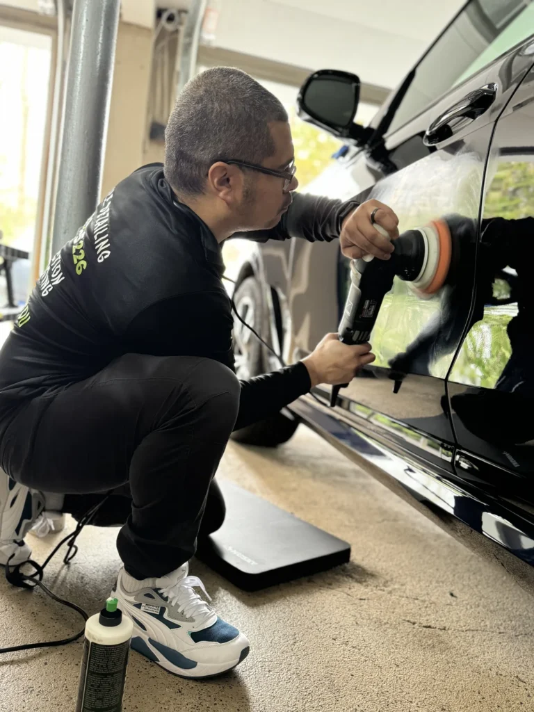 Two-stage machine correction on a black luxury sedan